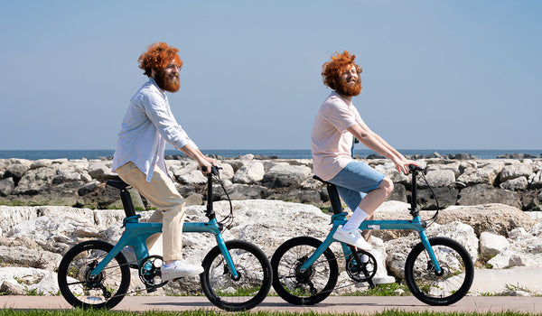 Zwei Männer fahren mit Elektrofahrrädern am Strand
