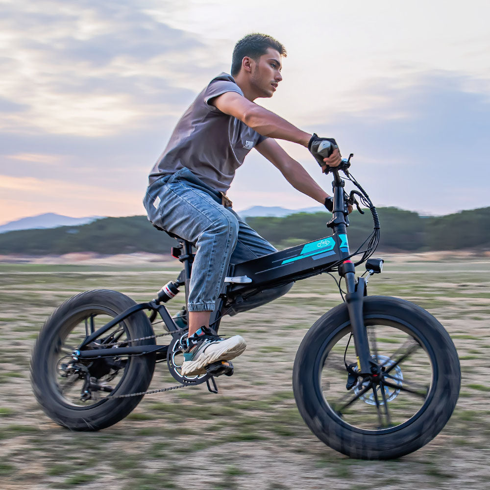 Mann fährt Fiido M1 Pro E-Bike beim Driften auf Sand