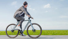 Ein Mann fährt mit einem Fiido Air-Elektrofahrrad mit voller Geschwindigkeit die Straße entlang.