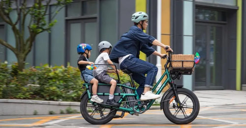 Ein Mann fährt zwei Kinder mit einem Fiido T2-Elektrofahrrad.