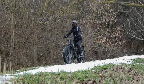 Eine Frau fährt mit einem Fiido Titan-Elektrofahrrad durch den Schnee