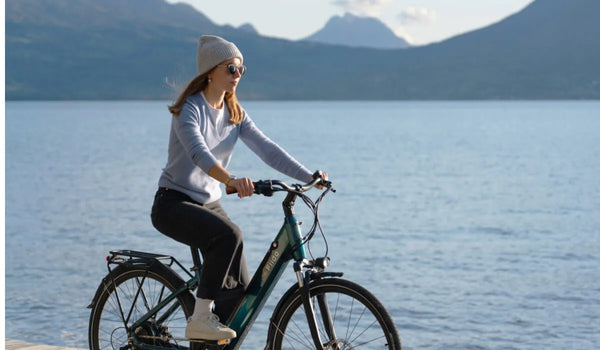 Eine Frau fährt mit einem Fiido C11 PRO Elektrofahrrad am See entlang