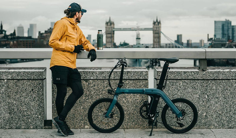 Mann und Elektrofahrrad Fiido D11 an der Brücke