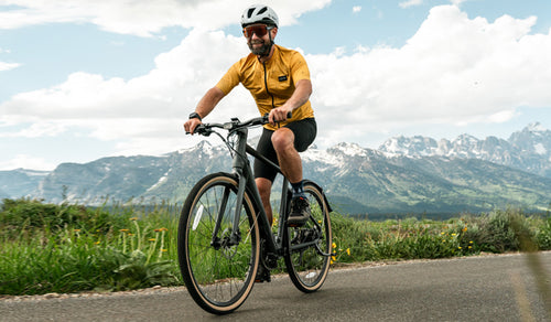 Ein Mann fährt mit seinem Fiido C21 E-Bike inmitten einer Berglandschaft.