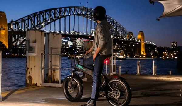 Ein Mann mit Helm fährt mit dem Fiido M1 Pro E-Bike nachts in der Stadt