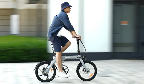 Ein Mann fährt mit einem Fiido D11 Elektrofahrrad auf einer Stadtstraße.