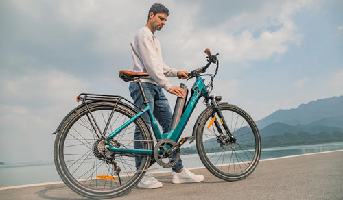 Ein Mann entnimmt den Akku aus einem leichten Elektrofahrrad vom Typ Fiido C11 Pro.