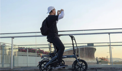 Ein Mann beobachtet den Sonnenuntergang auf dem Fiido L3 Elektrofahrrad