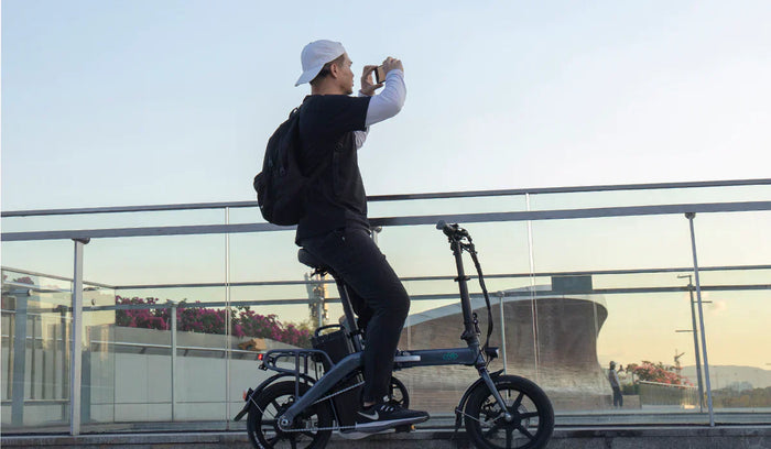 Ein Mann beobachtet den Sonnenuntergang auf dem Fiido L3 Elektrofahrrad