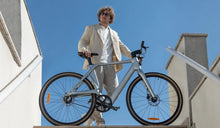 Ein Mann fährt ein Fiido Air E-Bike mit Carbonrahmen durch die Stadt.