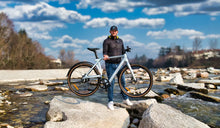 Ein Mann hebt das leichte E-Bike Fiido Air mühelos an.