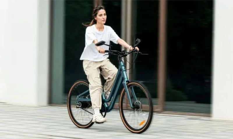 Eine Frau fährt mit einem Fiido C11Pro-Elektrofahrrad mit Rückspiegel los
