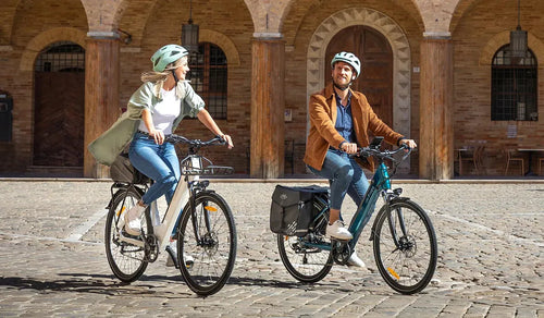 Ein Mann und eine Frau fahren mit einem Fiido C11 City-E-Bike auf einer Schotterstraße.