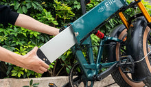 Ein Mann entfernt den externen Akku eines Fiido M1 PRO-Elektrofahrrads.