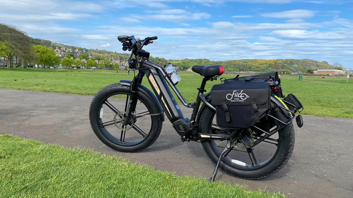 Fiido Titan E-Bike und Camel Bag am Straßenrand geparkt