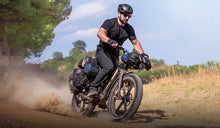 Ein Mann fährt mit einem Fiido Titan Fatbike schnell durch die Berge.