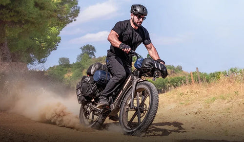 Ein Mann fährt mit einem Fiido Titan Fatbike schnell durch die Berge.