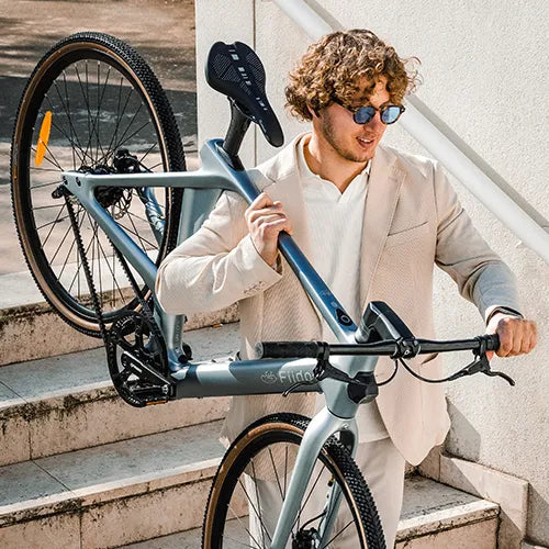 Mann trägt ein Fiido Carbon-E-Bike die Treppe hinunter